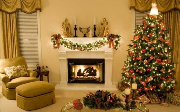 A cozy room featuring a decorated fireplace and a Christmas tree glowing with lights, 2K Desktop Wallpaper