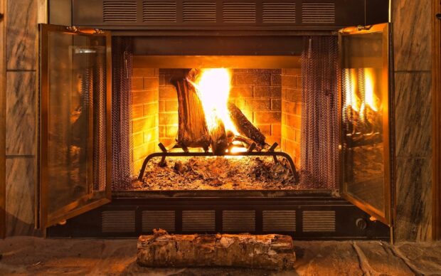 A burning fireplace with glowing logs surrounded by a brick interior, HD Desktop Wallpaper