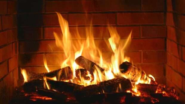 A bright fireplace fire with burning logs in a brick enclosure, 2K Desktop Wallpaper