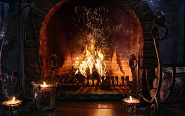 A cozy glowing fireplace in a rustic stone hearth with burning candles around it, HD Desktop Wallpaper