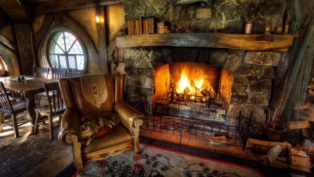 A warm stone fireplace with burning fire and a leather armchair in a rustic room, HD Desktop Wallpaper