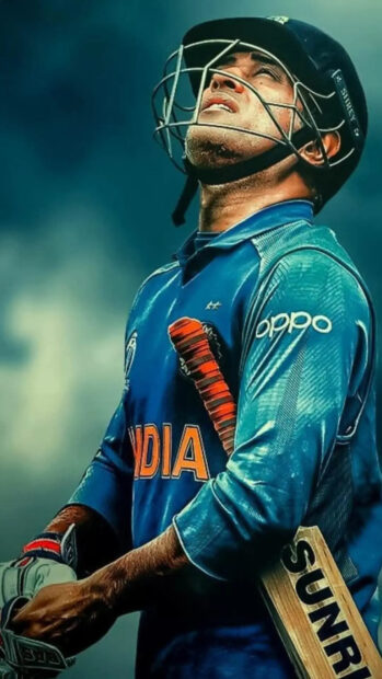 A cricket player wearing an India jersey looks up while holding a cricket bat