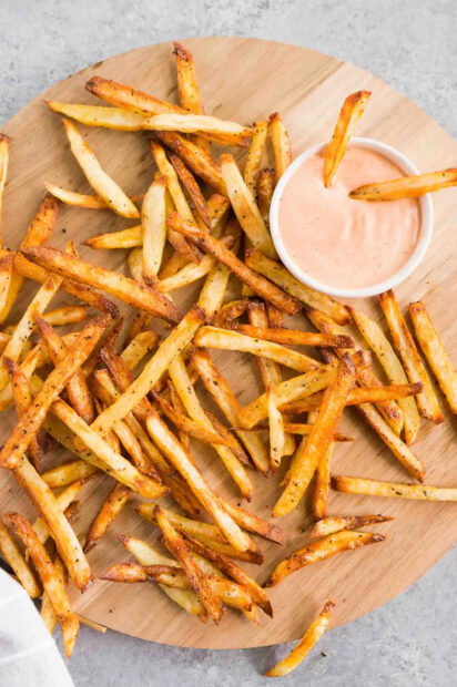 Crispy French fries served on a wooden board with dipping sauce, HD Mobile Wallpaper