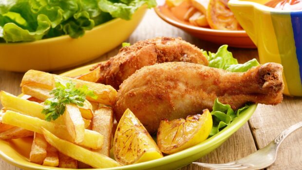 A plate of crispy fried chicken served with golden French fries and grilled lemon wedges, 2K Desktop Wallpaper