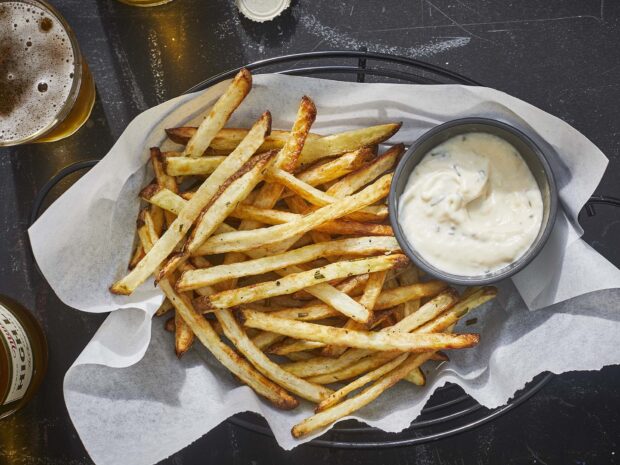 A basket of crispy golden French fries served with a creamy dipping sauce and a glass of beer, HD Desktop Wallpaper