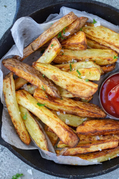 A close up of French fries seasoned with herbs and served with ketchup, 2K Mobile Wallpaper