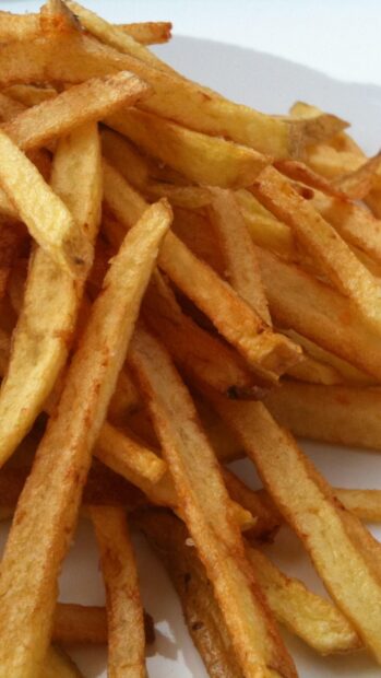 A close up view of crispy golden french fries stacked together, HD Phone Wallpaper