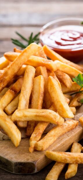 A close up of crispy golden french fries served with a bowl of ketchup dip, 2K Phone Wallpaper
