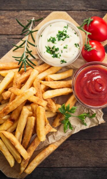 A plate of crispy golden fries served with ketchup and mayonnaise garnished with herbs, HD Phone Wallpaper