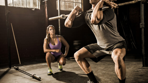 A man lifts a barbell while a woman watches during Crossfit training, HD Desktop Wallpaper