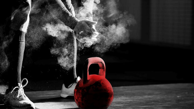 A person prepares with chalk hands for Crossfit training using a red kettlebell, HD Desktop Wallpaper