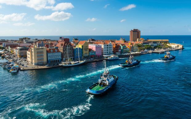 Colorful Curacao Island cityscape with boats sailing on the clear blue sea