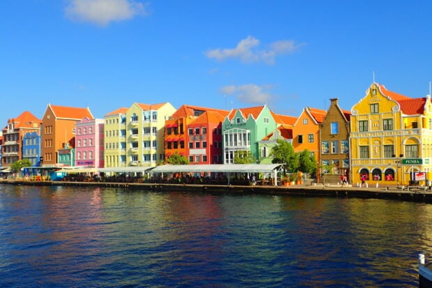 Colorful Curacao buildings line the waterfront under a clear blue sky