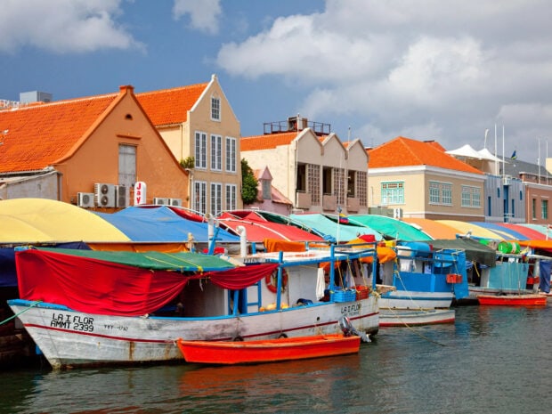 Colorful vessels docked at the harbor in Curacao Island with vibrant roofs