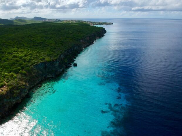 Aerial view of Curacao Island coast with turquoise water and lush greenery on the shore