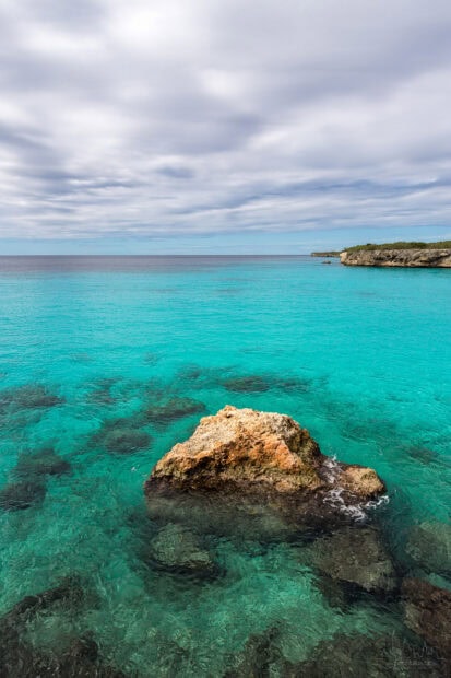 Clear turquoise water and rocky shore of Curacao Island surrounded by calm sea