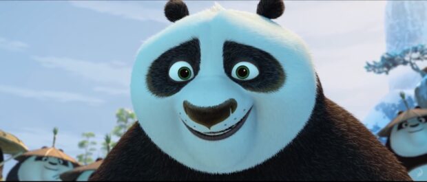 The panda character from Kung Fu Panda 3 is smiling with a blurred background of other pandas, 2K Desktop Wallpaper