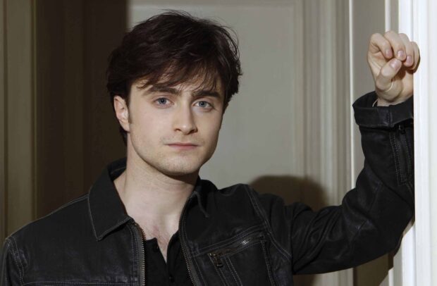 Daniel Radcliffe Wallpapers features him in a black jacket leaning against a white wall, HD Desktop Wallpaper
