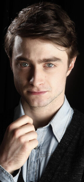 Daniel Radcliffe Wallpapers featuring a close up of his face and hand adjusting collar, HD Mobile Wallpaper