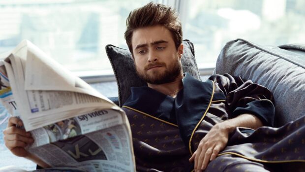 Daniel Radcliffe reading a newspaper while relaxing on a sofa, HD Desktop Wallpaper