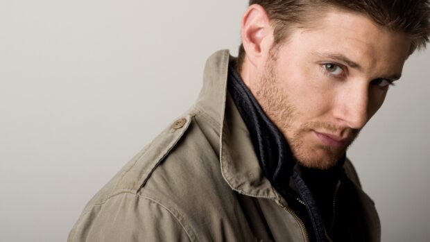 Close up of Dean Winchester wearing a jacket and looking intensely at the camera