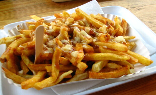 A tray of fries covered with cheese curds and gravy on a wooden table, HD Desktop Wallpaper