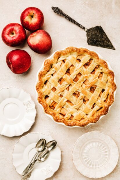 A freshly baked lattice apple pie surrounded by red apples and utensils, HD Desktop Wallpaper
