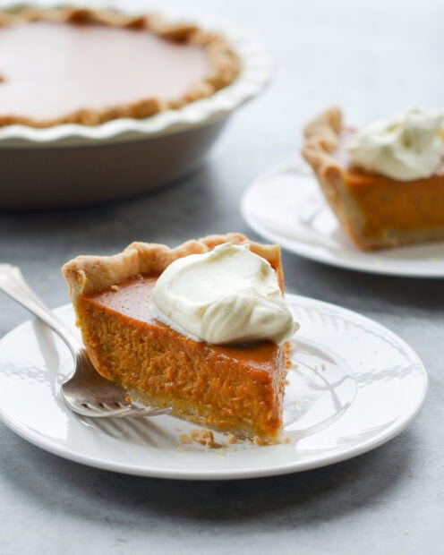 A slice of pumpkin pie topped with whipped cream sits ready to be eaten, 2K Desktop Wallpaper