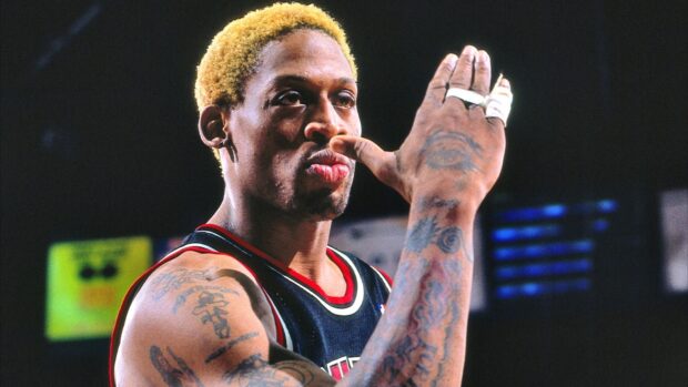 Dennis Rodman showing his tattoos and bandaged fingers during a basketball game