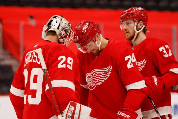 Detroit Red Wings players in red uniforms during a hockey game discussion