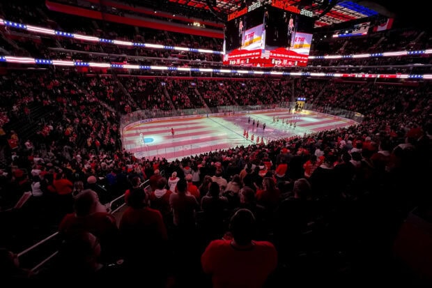 A packed arena with Detroit Red Wings players lined up on the ice during a pregame ceremony