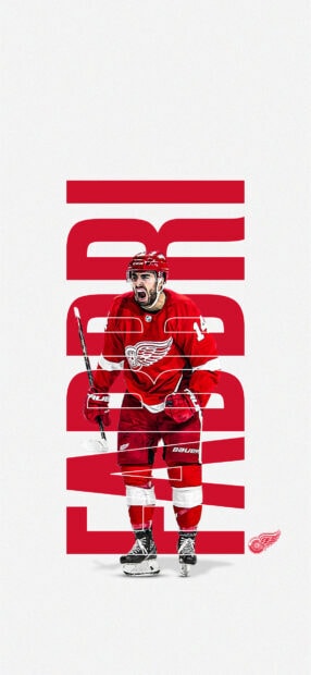 Detroit Red Wings player celebrating with hockey stick in red uniform