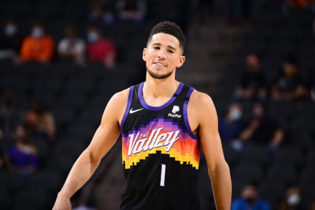 Devin Booker is smiling during a basketball game in a colorful jersey, 2K Desktop Wallpaper
