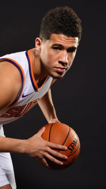 Devin Booker is holding a basketball preparing for a shot in a studio, 2K Phone Wallpaper