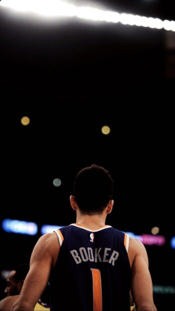 Devin Booker is standing on the basketball court wearing his jersey, HD Phone Wallpaper