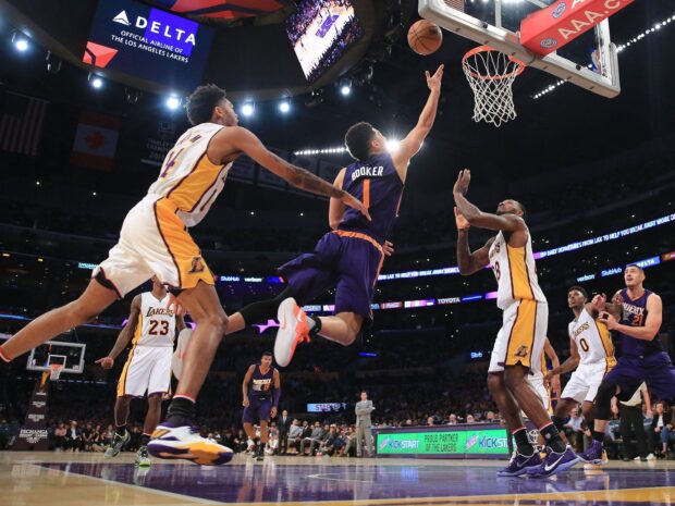 Devin Booker scores a layup against the Lakers in a crowded arena, HD Desktop Wallpaper