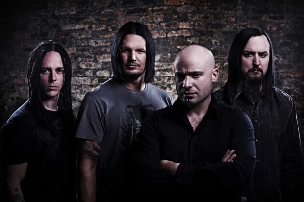 The Disturbed band stands posing with serious expressions in front of a textured brick wall, HD Desktop Wallpaper