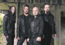 Band of four men wearing black leather jackets under a concrete bridge.