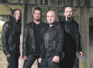 Band of four men wearing black leather jackets under a concrete bridge.