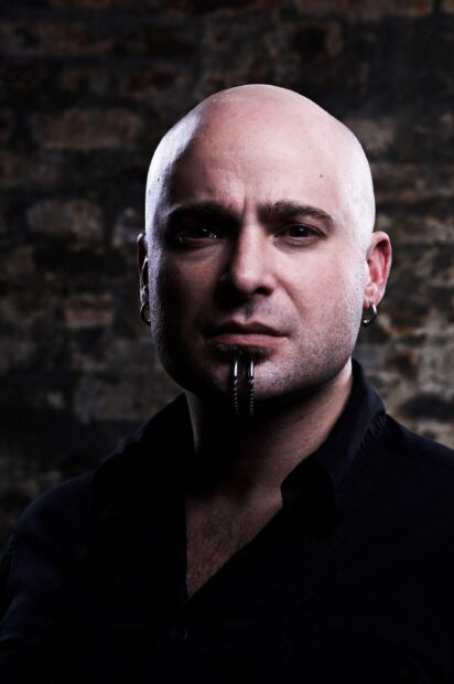 A close up of a disturbed band singer with facial piercings and intense expression, 2K Mobile Wallpaper