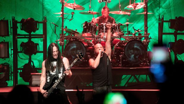 Disturbed band performing live with intense energy and green stage lights, 2K Desktop Wallpaper