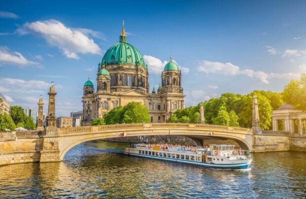 Một góc nhìn tuyệt đẹp của Dom Berlin với một chiếc thuyền đang lướt trên sông và những hàng cây xanh xung quanh, Hình nền máy tính HD