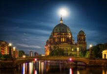 Dom Berlin stands illuminated beside the river reflecting city lights at night, HD Desktop Wallpaper