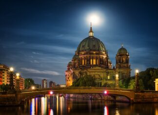 Dom Berlin stands illuminated beside the river reflecting city lights at night, HD Desktop Wallpaper