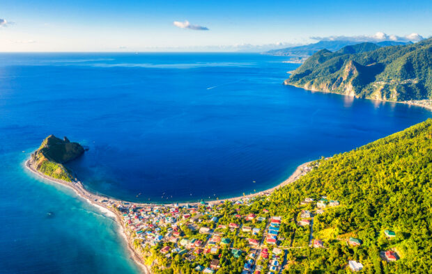 Aerial view of Dominica Island shows lush greenery and blue ocean waters, HD Desktop Wallpaper