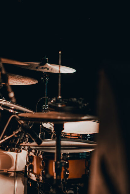 A detailed view of a drum set with cymbals in a dark room featuring drums, HD Mobile Wallpaper