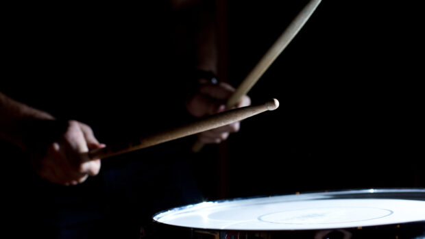 A close up of drumsticks hitting a drum during a performance, HD Desktop Wallpaper