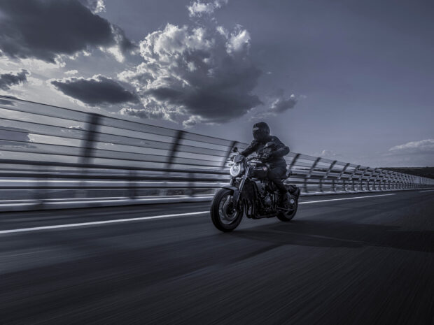A rider on a Honda Cb1000R is speeding along a highway under a cloudy sky, HD Desktop Wallpaper