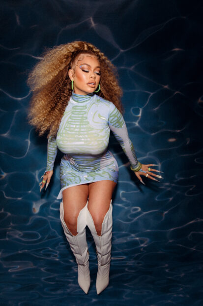A woman with curly hair poses wearing a patterned dress and white boots in Latto Wallpapers, HD Phone Wallpaper