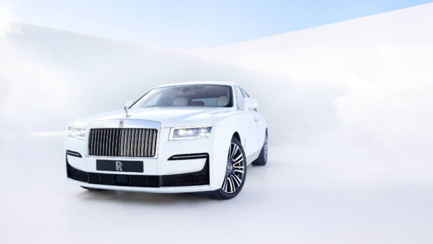 A white Rolls Royce Ghost is shown from the front with its headlights on, 4K Desktop Wallpaper